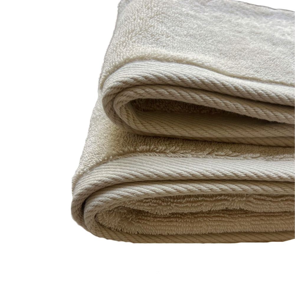 שתי מגבות פנים/ידיים בצבע חול של Fine Lab Home מקופלות בקפידה, מונחות זו על גבי זו על רקע לבן.