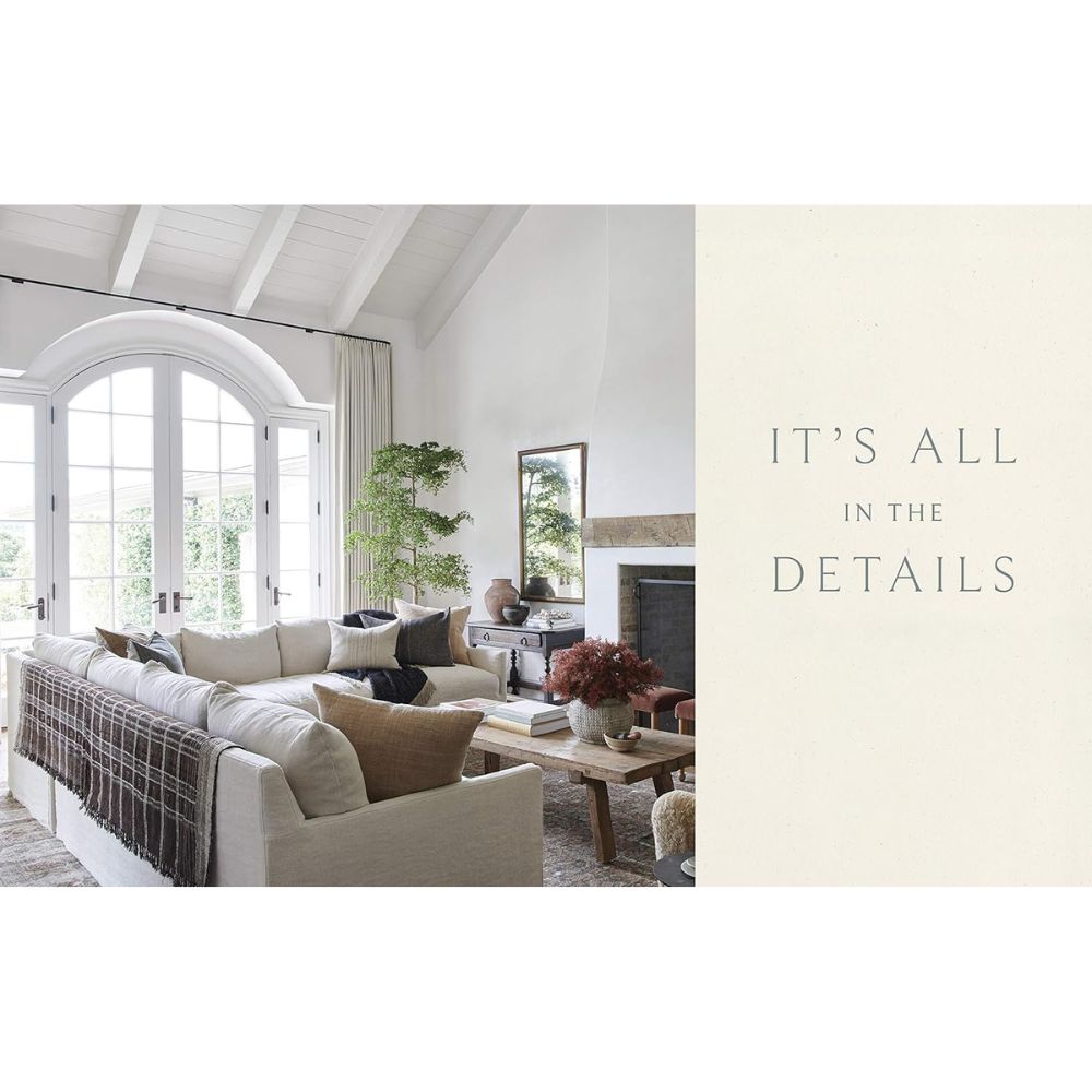 סלון מואר עם תקרה מקומרת, חלונות מקושתים, ריהוט ניטרלי ואח. ספר העיצוב של Fine Lab Home, שנוצר עבור החיים, מוסיף קסם. הטקסט אומר: הכל נמצא בפרטים הקטנים.