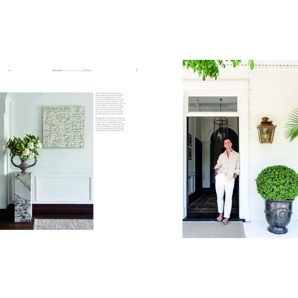 גבר לבוש בבגדים בהירים עומד בכניסה לבית לבן לצד עציץ גדול; בתמונה הבאה נראים רגעים מעיצוב הבית של Fine Lab Home עם בסיס שיש, אגרטל אלגנטי ואמנות קיר שנבחרה בקפידה.