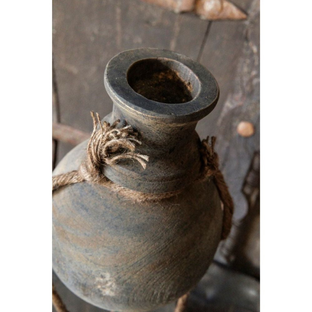 תקריב של החלק העליון של המוצר "כד דקורטיבי על סטנד מתכת – שני גדלים" מבית Fine Lab Home, עם חבל טבעי סביב הצוואר, על רקע עץ כפרי.