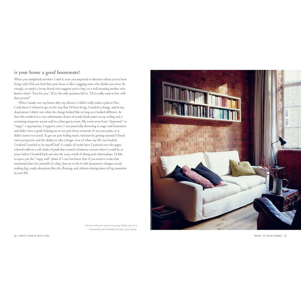 סלון עם ספה לבנה, כריות צבעוניות, שולחן קטן, מנורה, קירות לבנים ומדף ספרים מעל הספה. משמאל, טיפים לעיצוב הבית מתוך המדריך "עיצוב הבית מתחיל בבית" של Fine Lab Home, המופיע במטרה לשפר את איכות החיים.