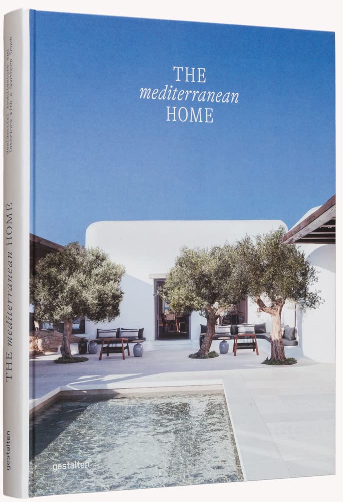 ספר העיצוב The Mediterranean Home מבית Fine Lab Home כולל תמונת כריכה של בית מודרני לבן עם בריכת שחיה ועצי זית, ומציג את סגנון המגורים והאדריכלות האלגנטית של אגן הים התיכון.