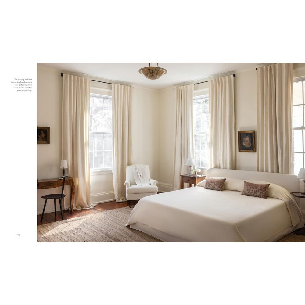 חדר שינה מואר עם קירות בצבע שמנת, חלונות גדולים ומצעים ניטרליים הוא השראה מושלמת לחובבי עיצוב פנים או לכל מי שמשתמש בספר העיצוב "The Essentials" של Fine Lab Home.