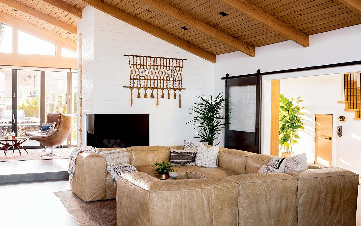 חדר רחצה מודרני עם כיורים כפולים, ארונות כהים, מראות, מגבות מגולגלות, שידה מרכזית, שטיחים אדומים, שרפרף כחול וצמחים – תמונה שנלקחה היישר מתוך סיפור הבית בספר העיצוב של Fine Lab Home.