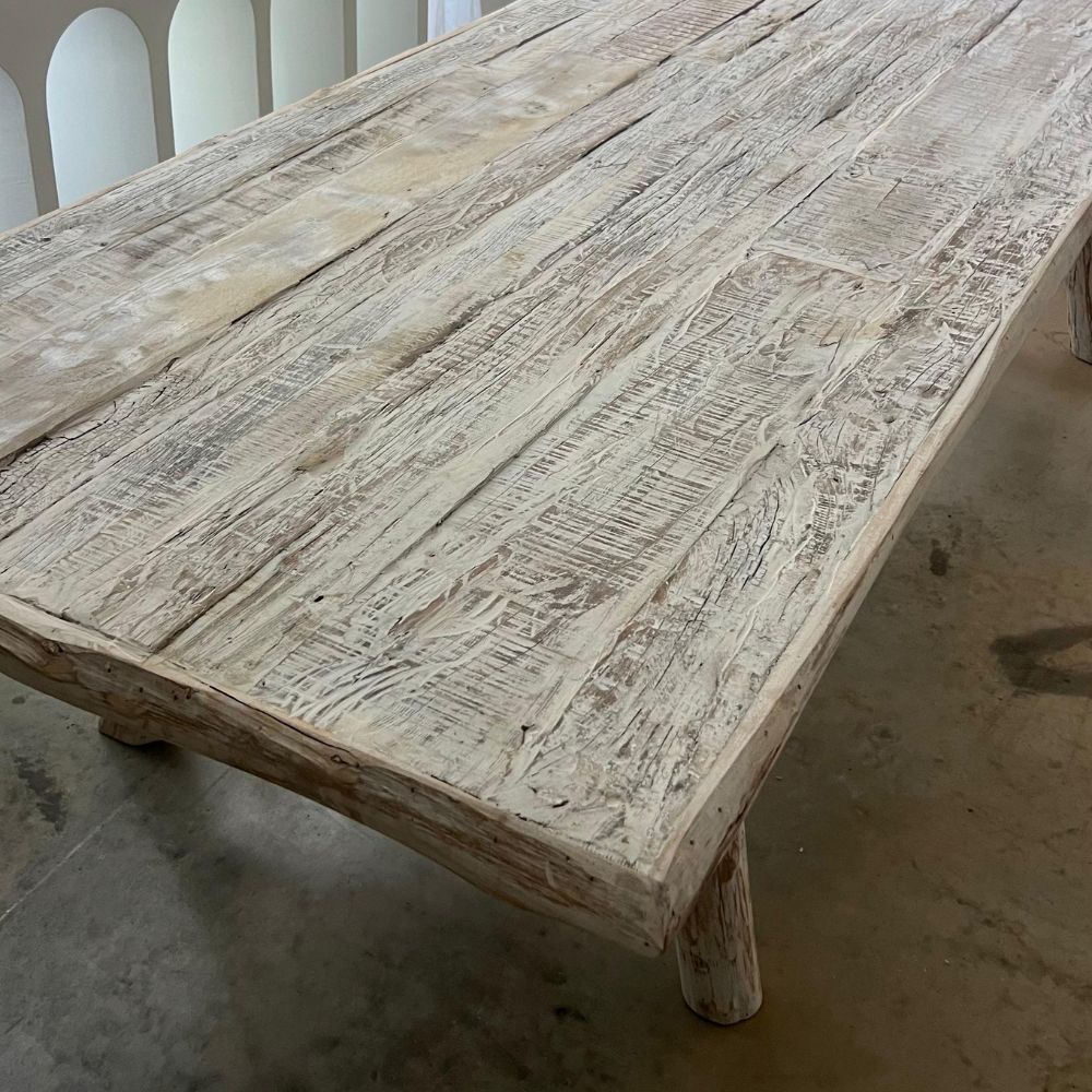 שולחן אוכל מעץ בגימור Whitewash משני גדלים של Fine Lab Home עומד על רצפת בטון, ומשדר קסם כפרי בעבודת יד.