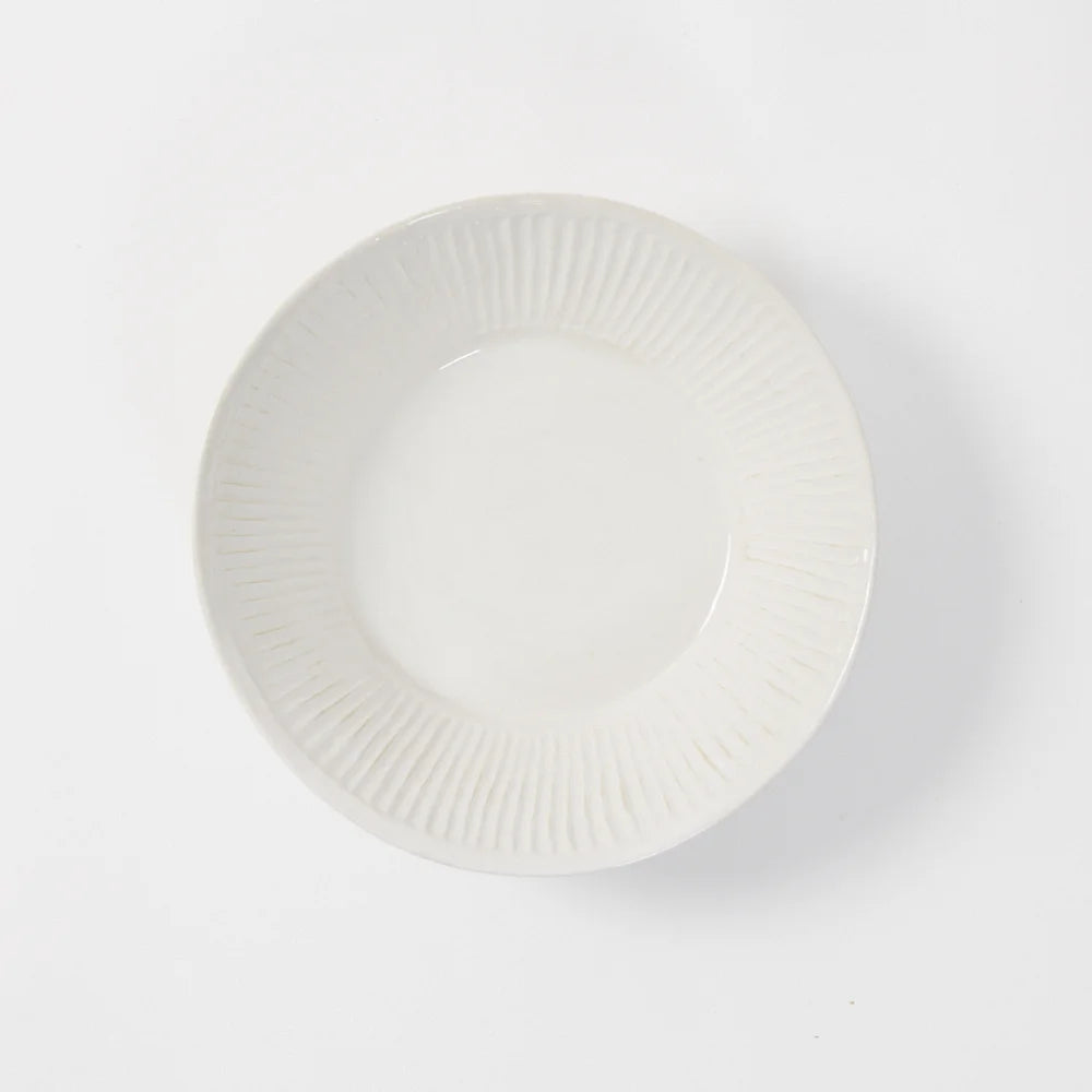 קערת סלט yolanda מבית Fine Lab Home היא צלחת קרמיקה לבנה ופשוטה עם שוליים מרקמים, שצולמה מלמעלה על רקע לבן, ומעוררת את הפשטות האלגנטית של קערה בעבודת יד.