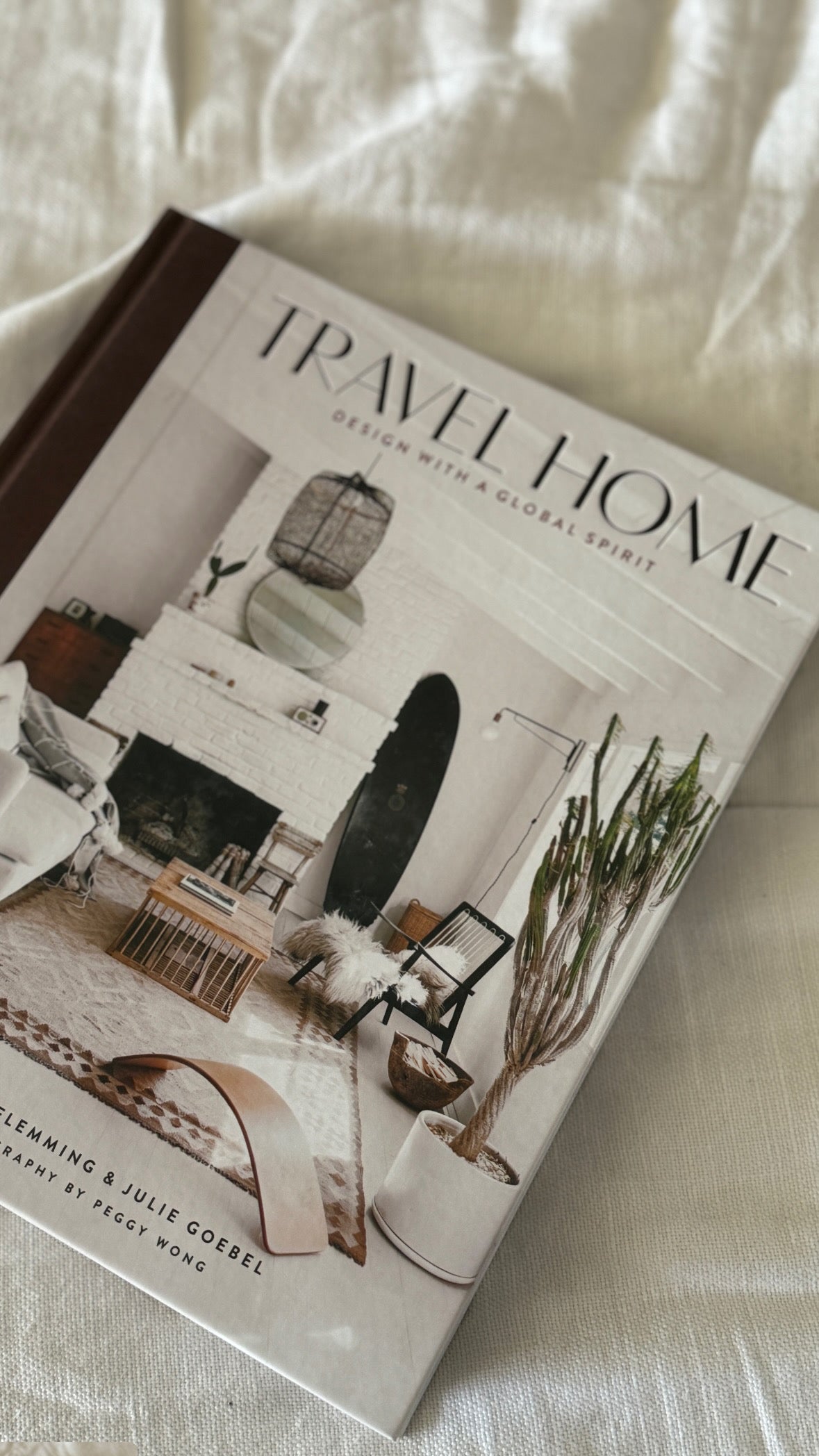 כריכת הספר "עיצוב בית" מאת Fine Lab Home, המציגה סלון מודרני עם קירות לבנים, אח, עיצוב אקלקטי וצמח קקטוס גבוה.