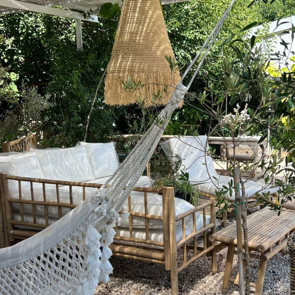 מערכת ישיבה פינתית מבמבוק טבעי מבית Fine Lab Home כוללת ספה עם מסגרת במבוק, כריות לבנות ושולחן קפה תואם — ריהוט גן אידיאלי לחלל החיצוני שלכם.
