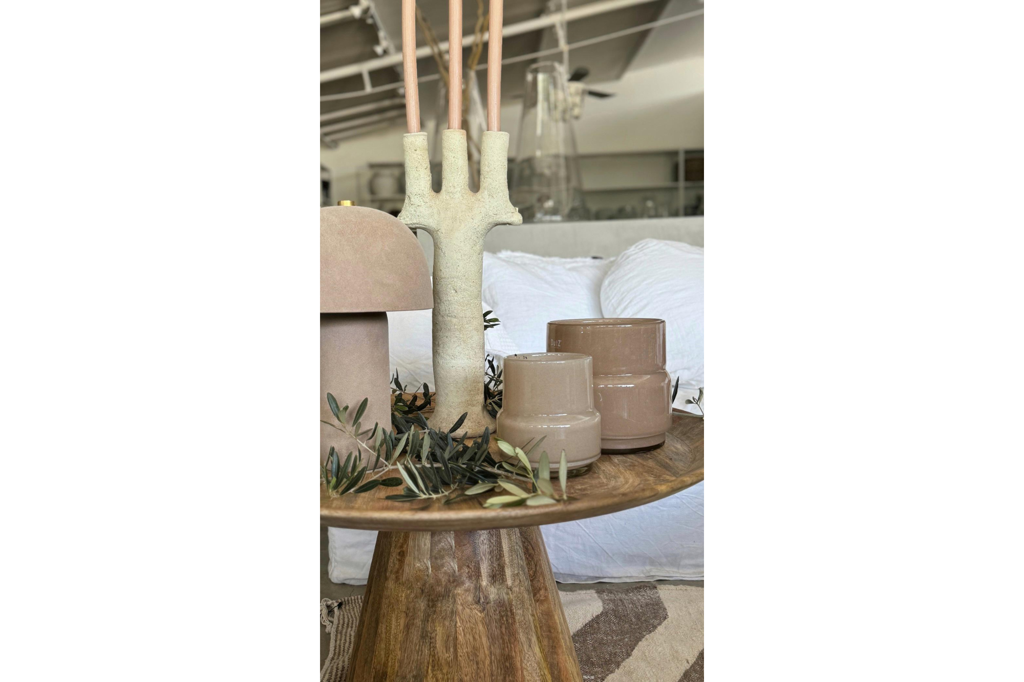 מנורת שולחן חול חומה מבית Fine Lab Home פולטת אור חם, ממוקמת על רקע לבן חלק.