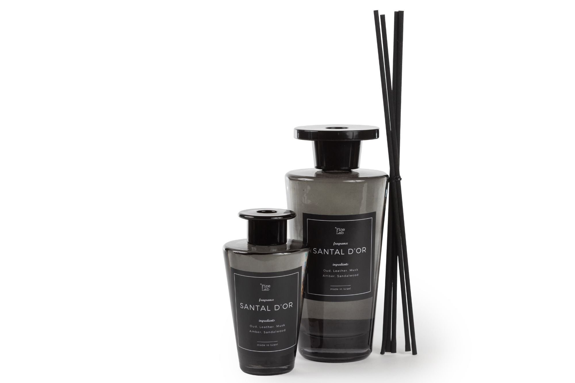 שני מפיץ ריח מקלות אלגנטיים בצבע שחור | santal d'or diffusers בגדלים שונים, עם מקלות קנה שחורים תואמים הנשענים על הבקבוק הגדול יותר, מבטיחים תערובת ריחות ייחודית על רקע לבן.