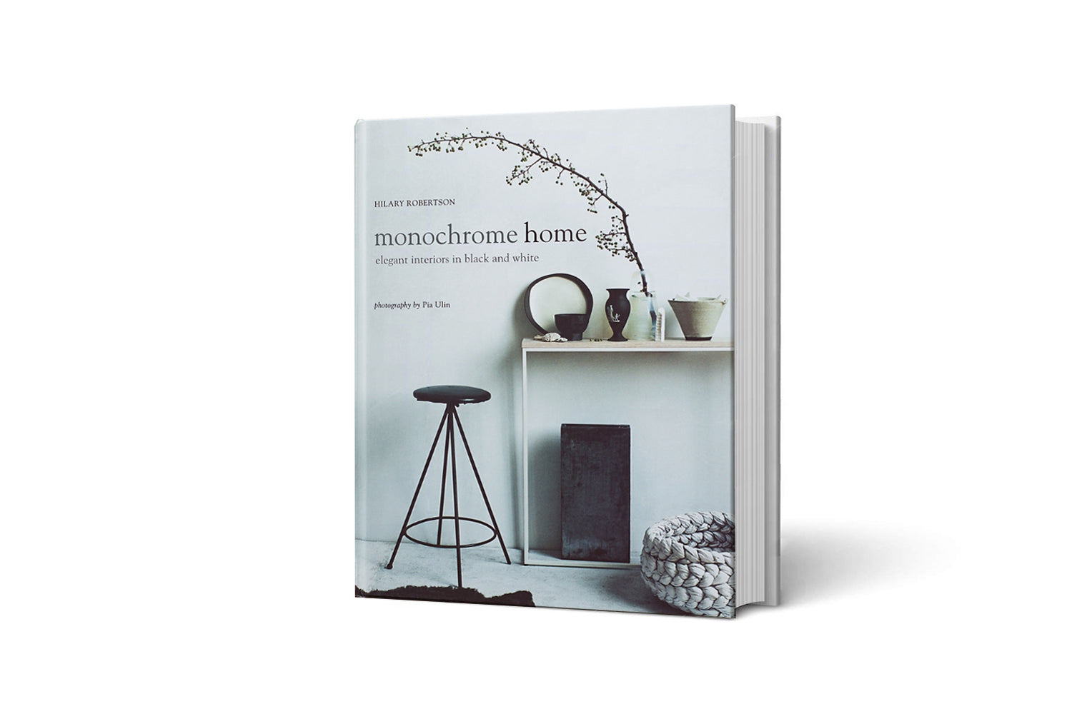 הספר בכריכה קשה "ספר עיצוב monochrome home" מאת Fine Lab Home מציג בעטיפתו סצנה מינימליסטית בשחור-לבן עם ריהוט ועיצוב פנים פשוטים.