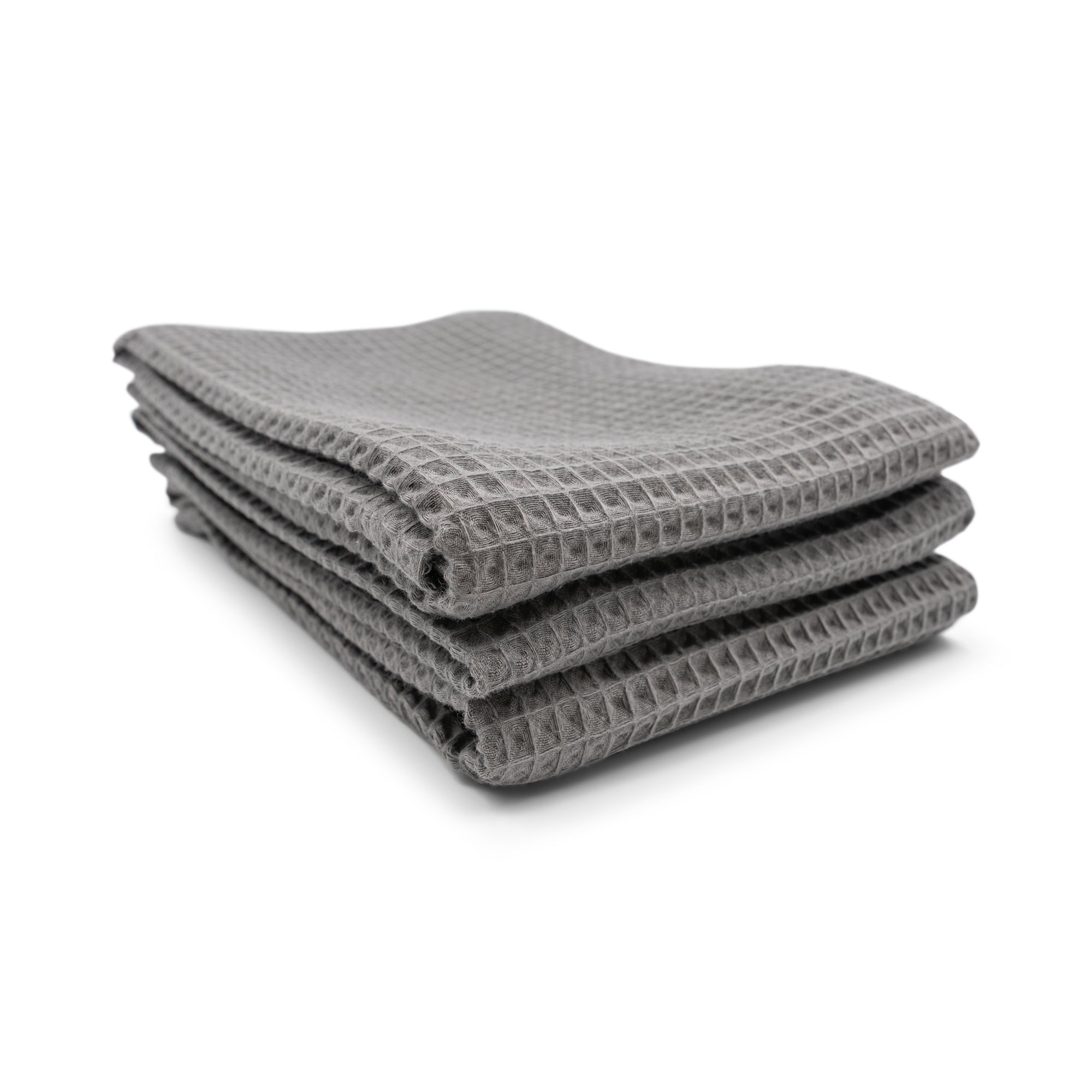 שלושה מגבות ידיים מקופלות של Fine Lab Home - 3 יחידות בצבע בז' באריגה וופל, עשויות מ-100% כותנה, מוערמות על רקע לבן.