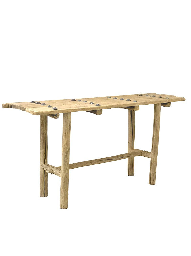הקונסולה עץ ניטים מבית Fine Lab Home היא ספסל עץ כפרי בעל גימור טבעי גס, טקסטורת עץ בולטת, ארבע רגליים לא אחידות ומתיחה אופקית, המיוצר כריהוט ידידותי לסביבה.