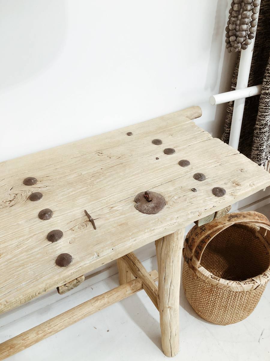 הקונסולה עץ ניטים מבית Fine Lab Home היא ספסל עץ כפרי בעל גימור טבעי גס, טקסטורת עץ בולטת, ארבע רגליים לא אחידות ומתיחה אופקית, המיוצר כריהוט ידידותי לסביבה.