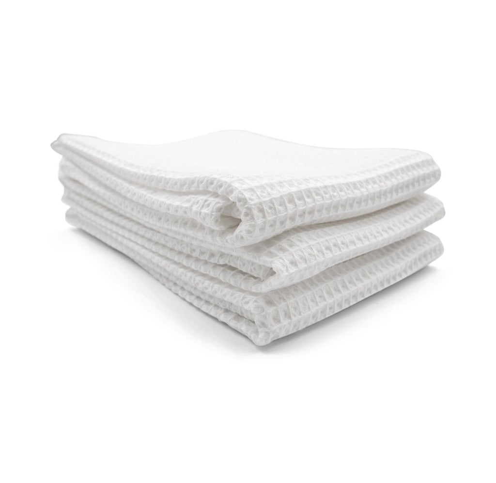 שלושה מגבות ידיים מקופלות של Fine Lab Home - 3 יחידות בצבע בז' באריגה וופל, עשויות מ-100% כותנה, מוערמות על רקע לבן.