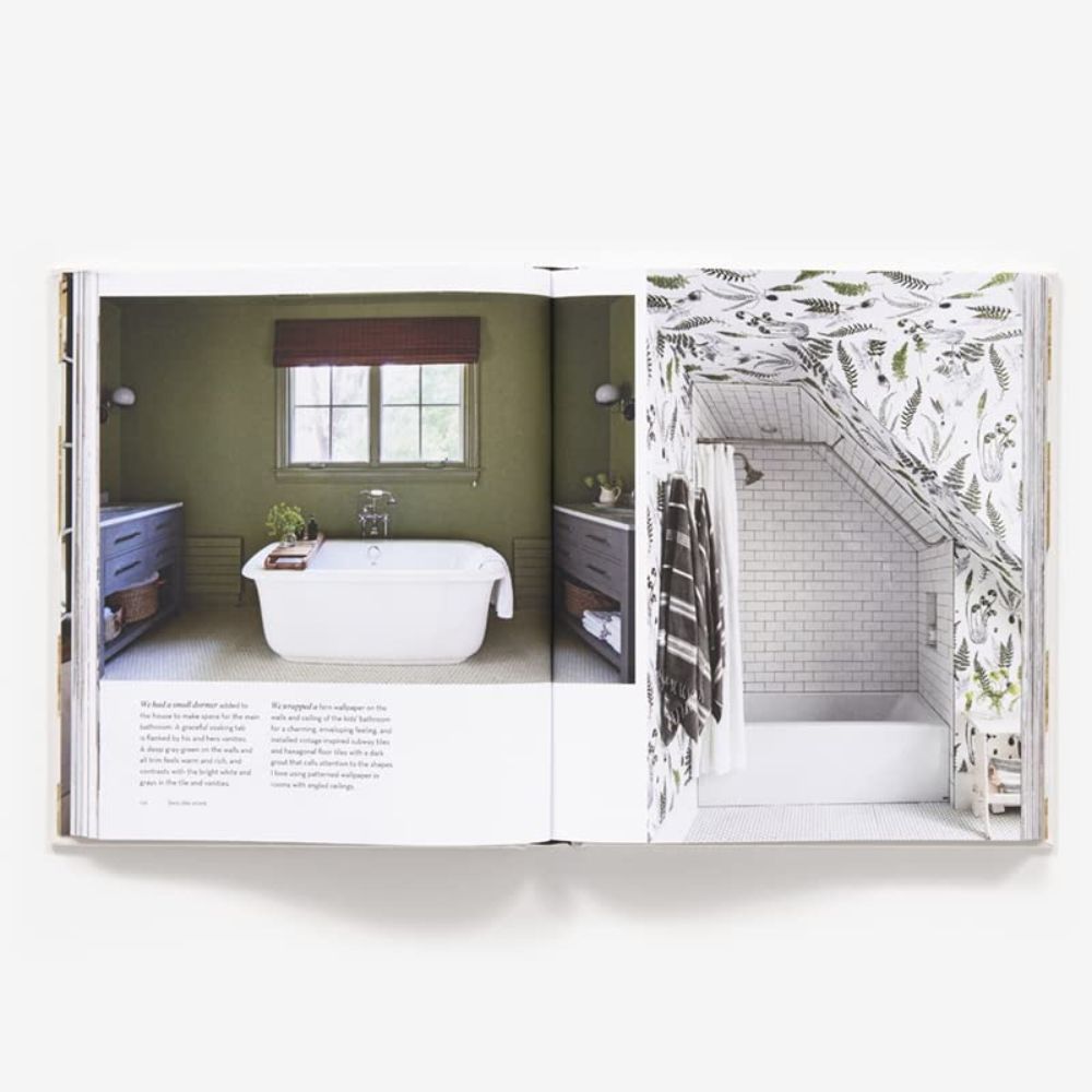 ספר עיצוב פתוח מרגיש כמו בית מאת Fine Lab Home מציג שני חדרי אמבטיה: האחד עם אמבטיה עומדת וקירות ירוקים, והשני עם טפטים מעוצבים ואמבטיה-מקלחת מרוצפת באריחים — חללים מזמינים שמרגישים באמת כמו בית.