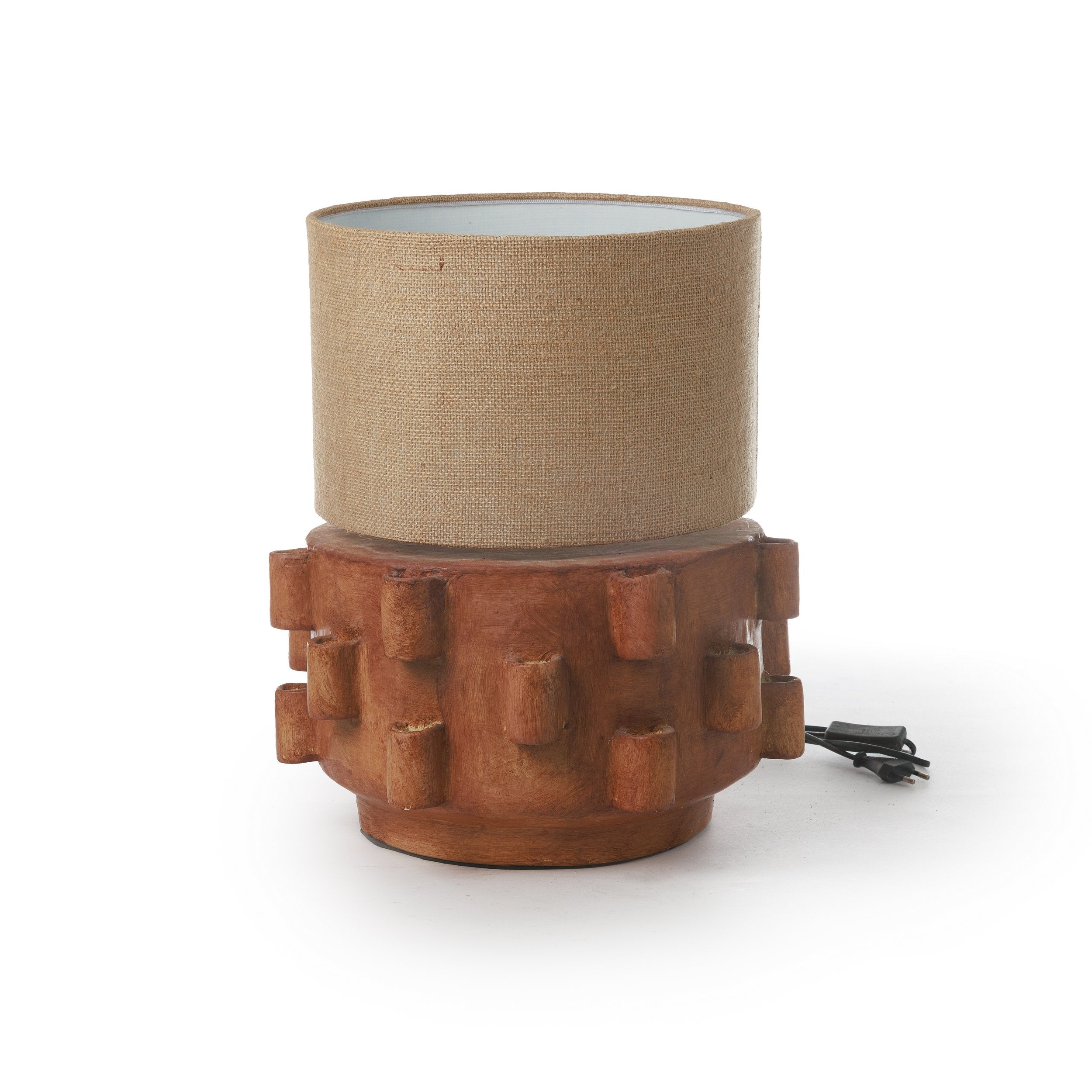 מנורת שולחן עם אהיל בד מבית Fine Lab Home: בסיס קרמי חום עם דוגמה גאומטרית ואהיל בד גלילי בגוון בז'. מתאימה לתאורה לבית בסגנון מודרני. כבל החשמל השחור נראה ברקע.