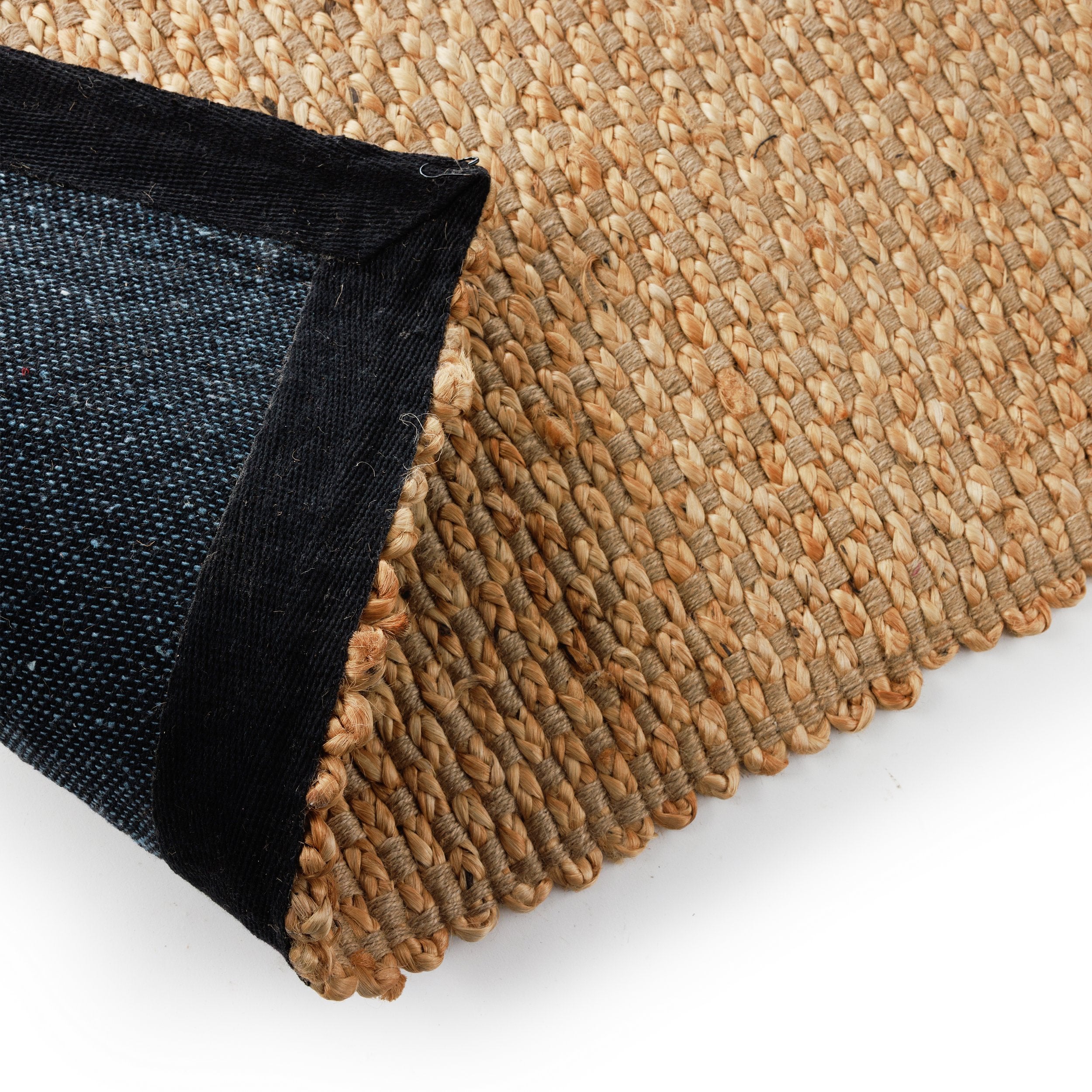 תקריב של שטיח חבל ביטנה - הדס מבית Fine Lab Home, שטיח מסיבים טבעיים עם חוטים עבים קלועים בתבנית מלבנית על רקע לבן.