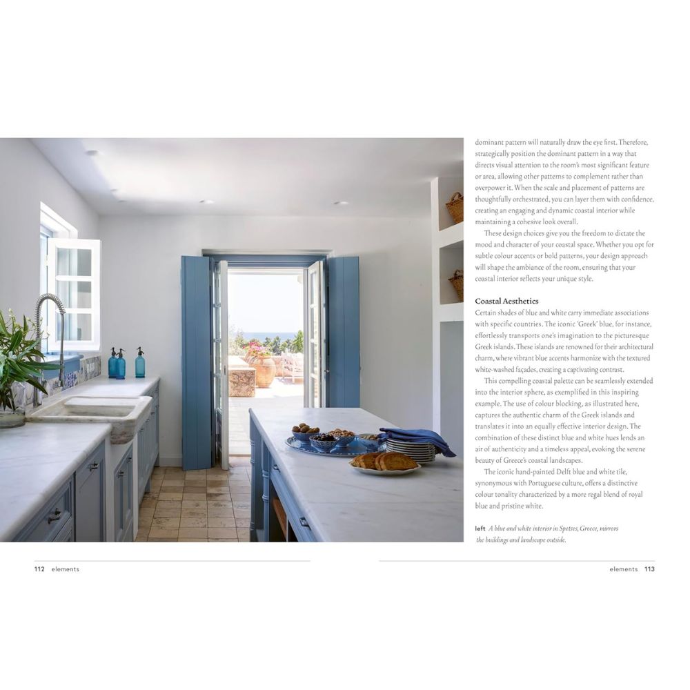 מטבח מואר עם משטחי עבודה לבנים, ארונות כחולים ודלתות כחולות פתוחות למרפסת שטופת שמש — קבלו השראה מעיצוב פנים בסגנון חופי עם ספר העיצוב החופי של Fine Lab Home.