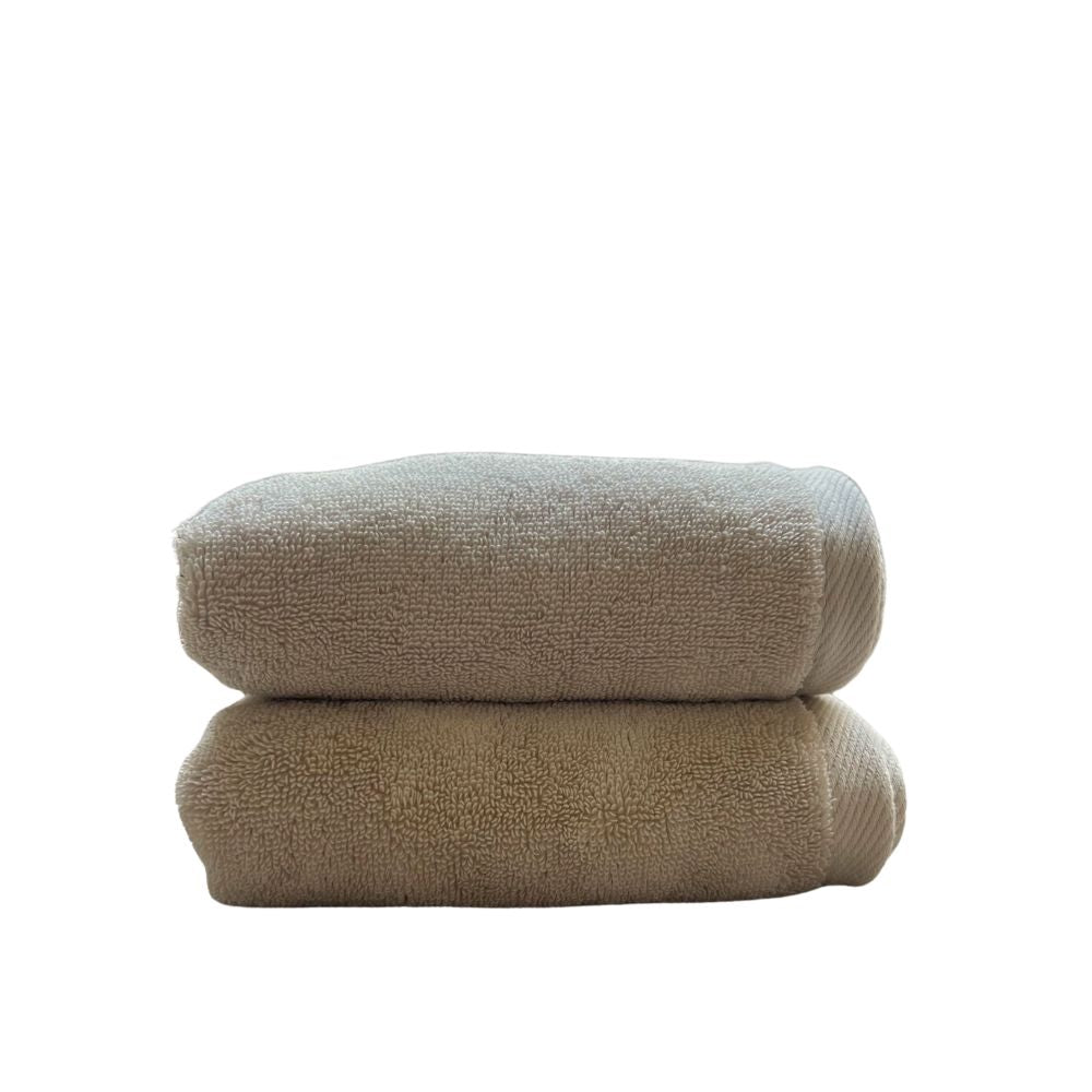 שני זוגות מגבות פנים/ידיים בצבע חול מבית Fine Lab Home מקופלות ומונחות זו על גבי זו על רקע לבן.