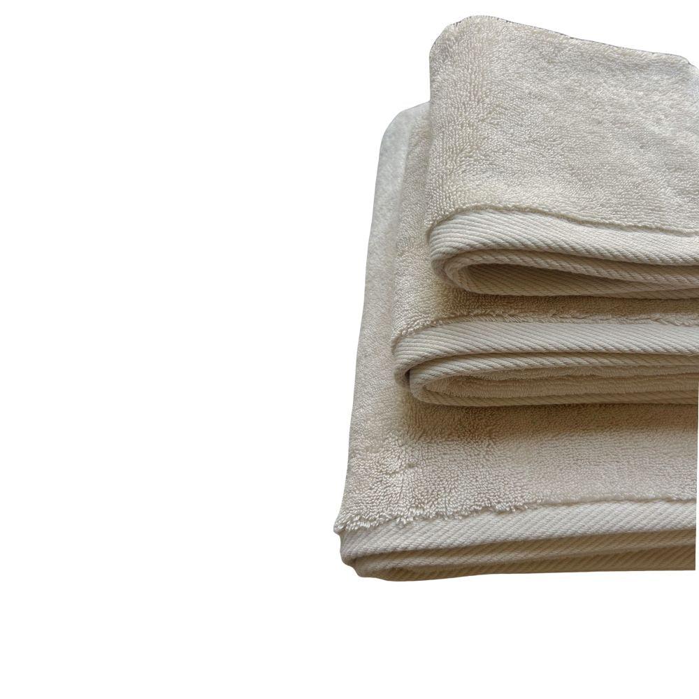 תקריב של שלוש מגבות Fine Lab Home מגבת גוף איכותית - צבע חול מקופלות בקפידה ומסודרות על רקע לבן חלק.