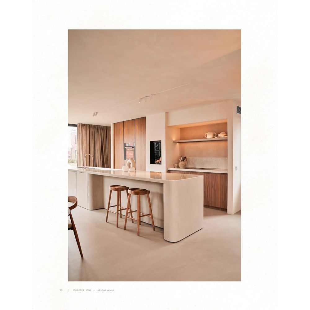 מטבח מינימליסטי מודרני עם אי לבן גדול, כסאות בר מעץ, מכשירי חשמל מובנים ומדפים פתוחים המעוצבים בסגנון Japandi בהשראת ספר העיצוב Japandi של Fine Lab Home לסגנון מינימליסטי ועיצוב פנים בהשראת Japandi.