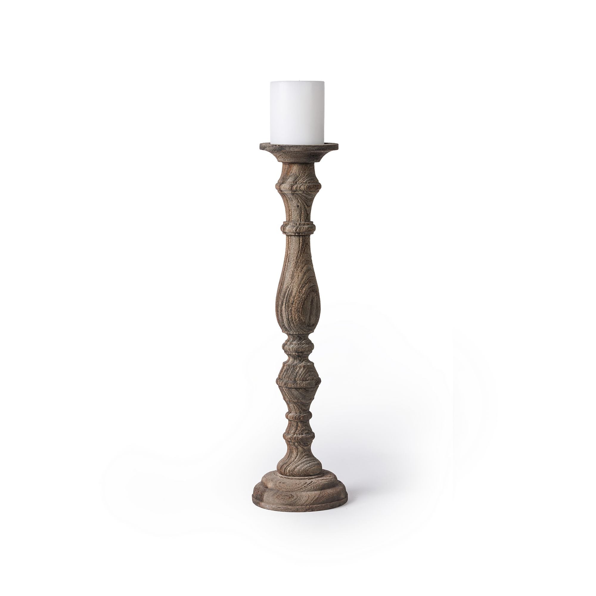 פמוט עץ מגולף גבוה - פמוט נרות בגודל XL מבית Fine Lab Home, עם גילופים מורכבים ומעליו נר עמוד לבן, על רקע לבן חלק.