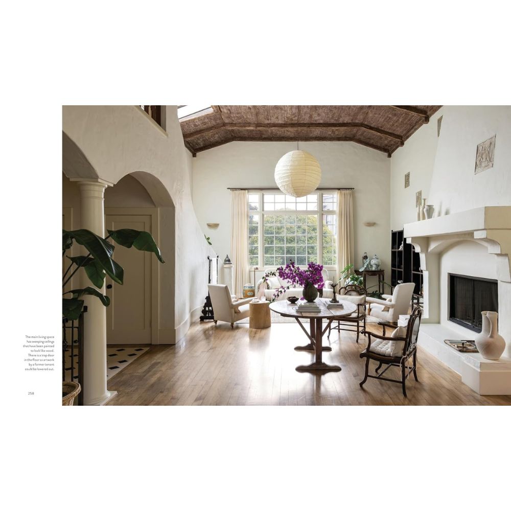 סלון מרווח עם חלונות גדולים, רצפות עץ, ריהוט אקלקטי ופנס עגול מתחת לתקרת קורות עץ — השראה מושלמת לספר "ספר עיצוב the essentials" של Fine Lab Home.