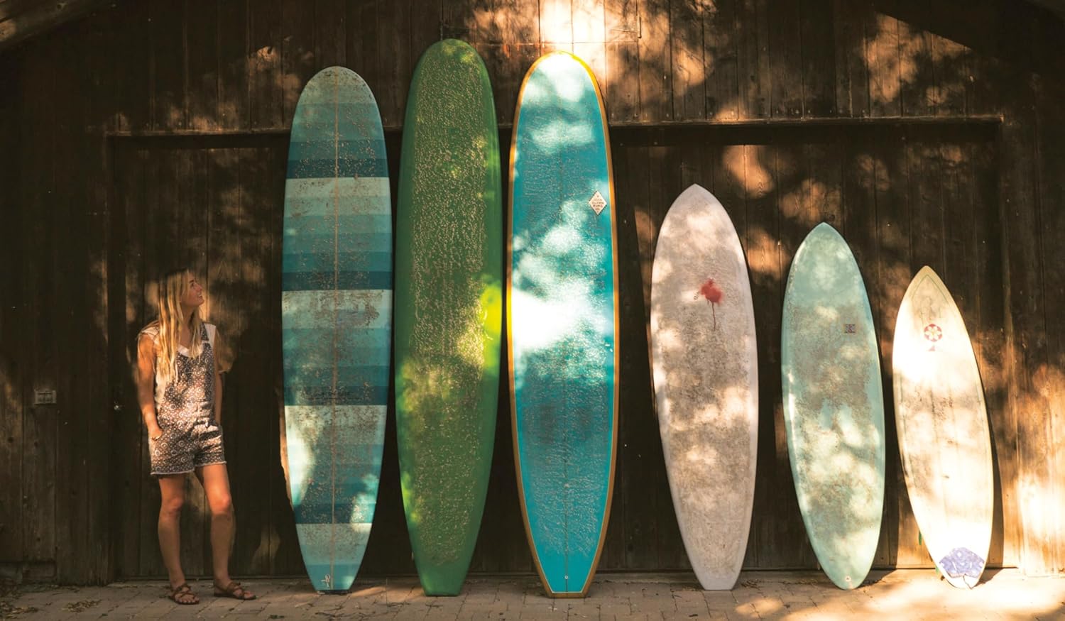 על עטיפת הספר "ספר עיצוב surf shacks" מאת Fine Lab Home מופיע הכותרת לצד שלוש תמונות של בתים כפריים בהשראת גלישה.