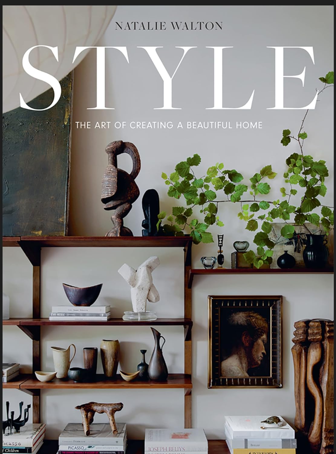 ספר עיצוב Style: The Art of Creating a Beautiful Home מבית Fine Lab Home, מוצג לצד אובייקטי אמנות, ואזה ויצירות ממוסגרות – השראה לבית ולעיצוב הבית.
