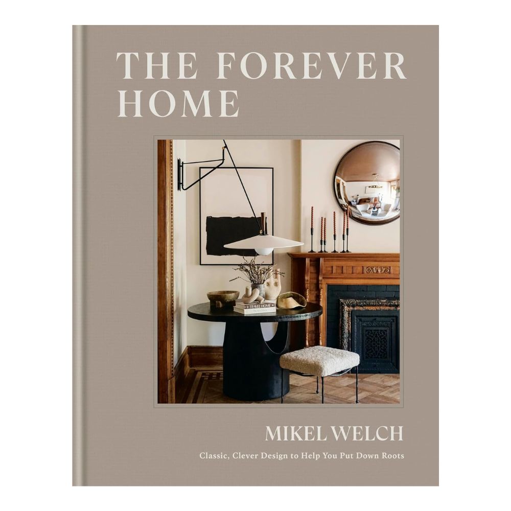 כריכת ספר העיצוב The Forever Home מבית Fine Lab Home מציגה פינת אוכל מודרנית עם שולחן עגול, כיסאות, אמנות קיר ומראה עגולה מעל האח—השראה מושלמת למדריך עיצוב הבית שלך.