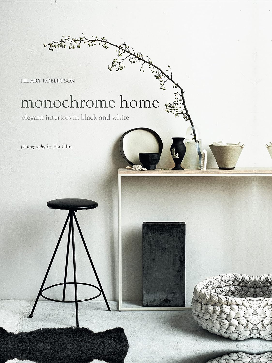 הספר בכריכה קשה "ספר עיצוב monochrome home" מאת Fine Lab Home מציג בעטיפתו סצנה מינימליסטית בשחור-לבן עם ריהוט ועיצוב פנים פשוטים.