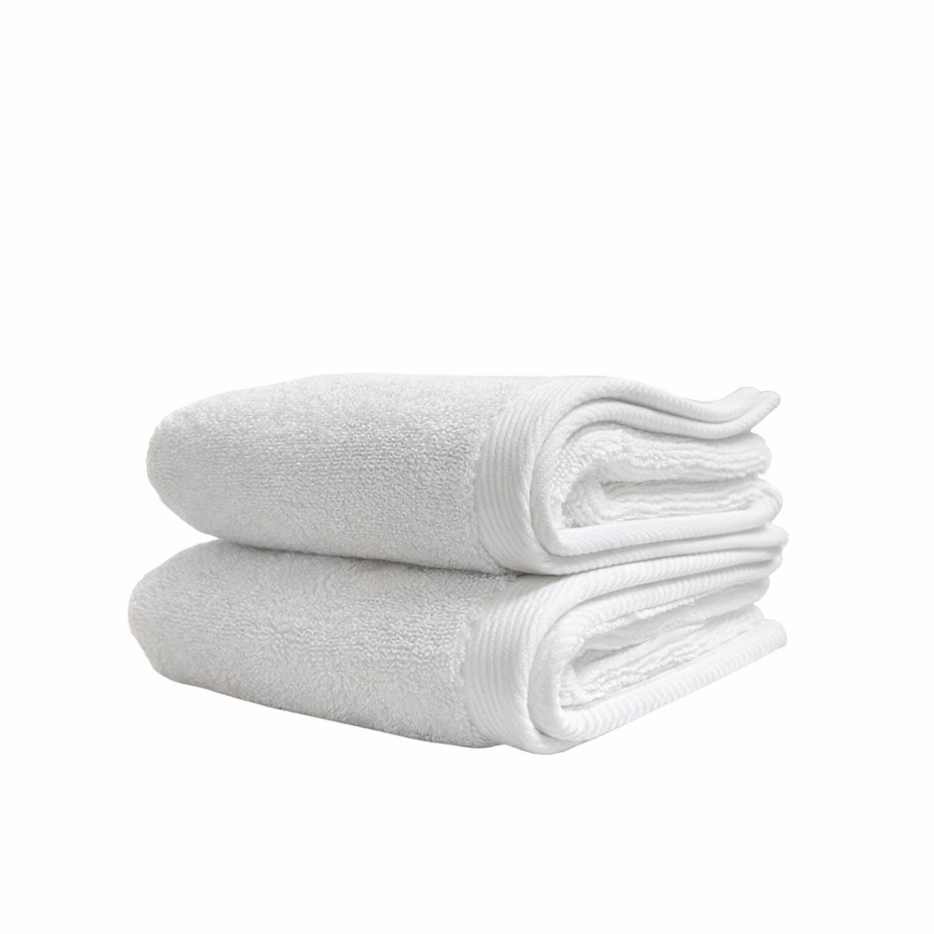 שתי מגבות פנים/ידיים בצבע לבן מבית Fine Lab Home מונחות זו על גבי זו על רקע לבן.
