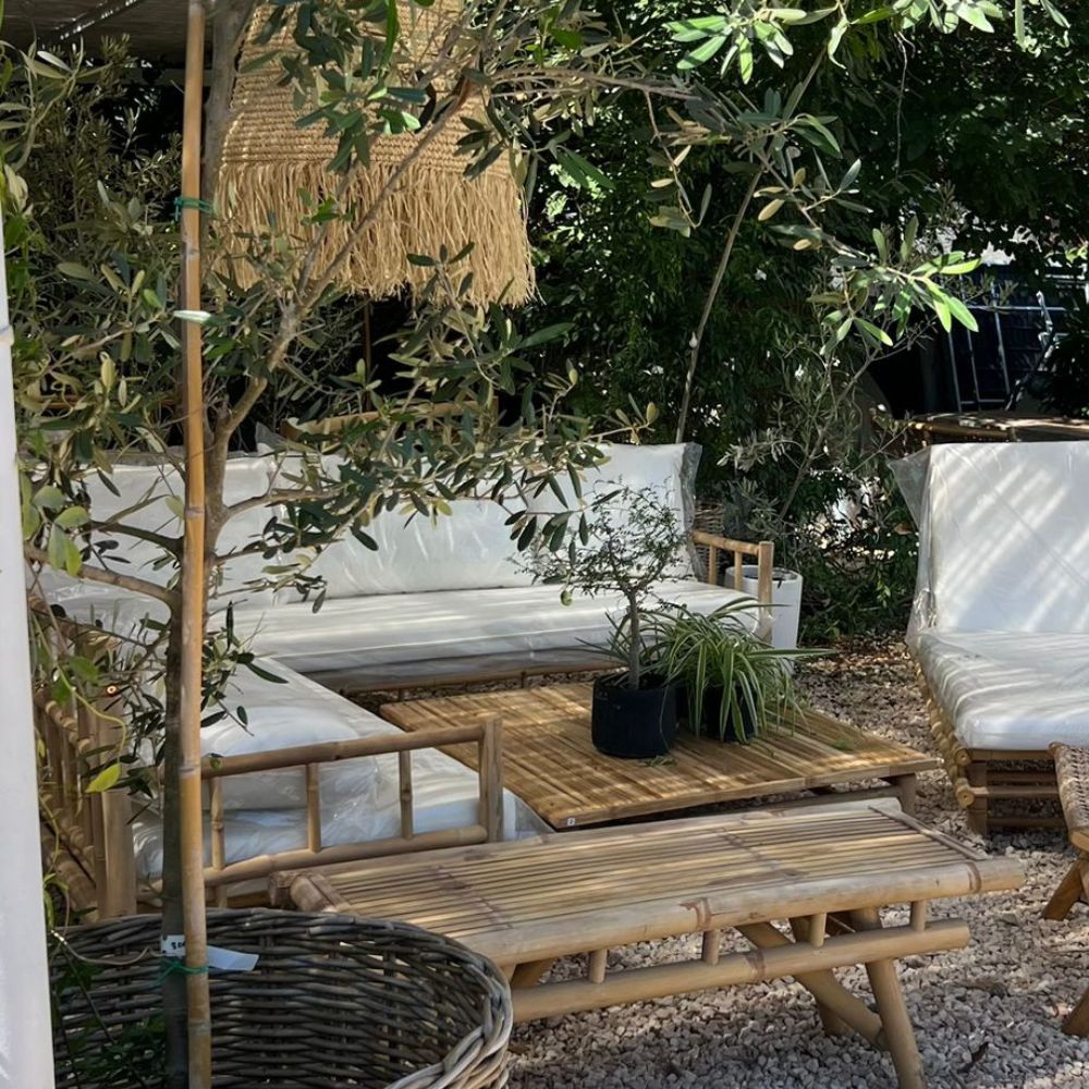 מערכת ישיבה פינתית מבמבוק טבעי מבית Fine Lab Home כוללת ספה עם מסגרת במבוק, כריות לבנות ושולחן קפה תואם — ריהוט גן אידיאלי לחלל החיצוני שלכם.
