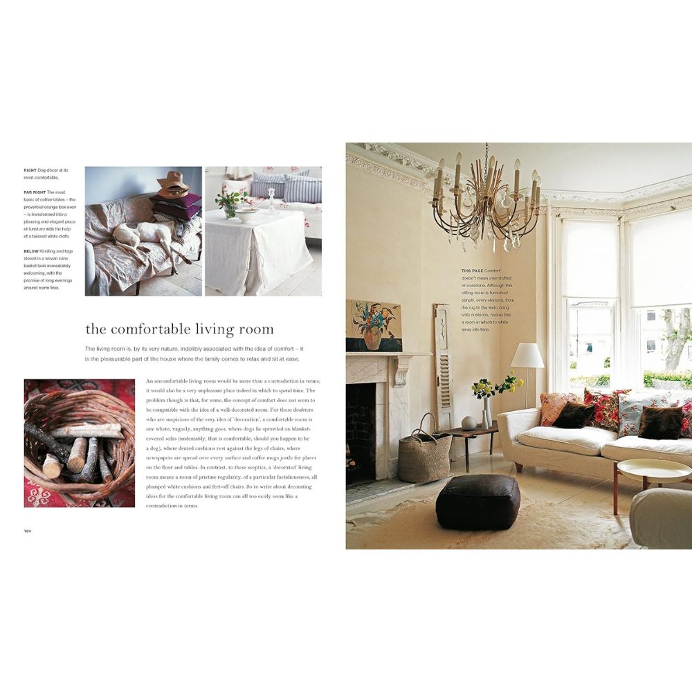 בעמוד פתוח של הספר "The Comforts of Home" בהוצאת Fine Lab Home נראית סלון נעים ומלא אור, עם ריהוט בגוונים ניטרליים, נברשת, חלונות גדולים וכריות נוי — היוצרים אווירה ביתית וחמימה מושלמת. בעמוד השמאלי מופיעים טקסט ותמונות קטנות שנועדו לעורר השראה לרעיונות חדשים לעיצוב הבית.
