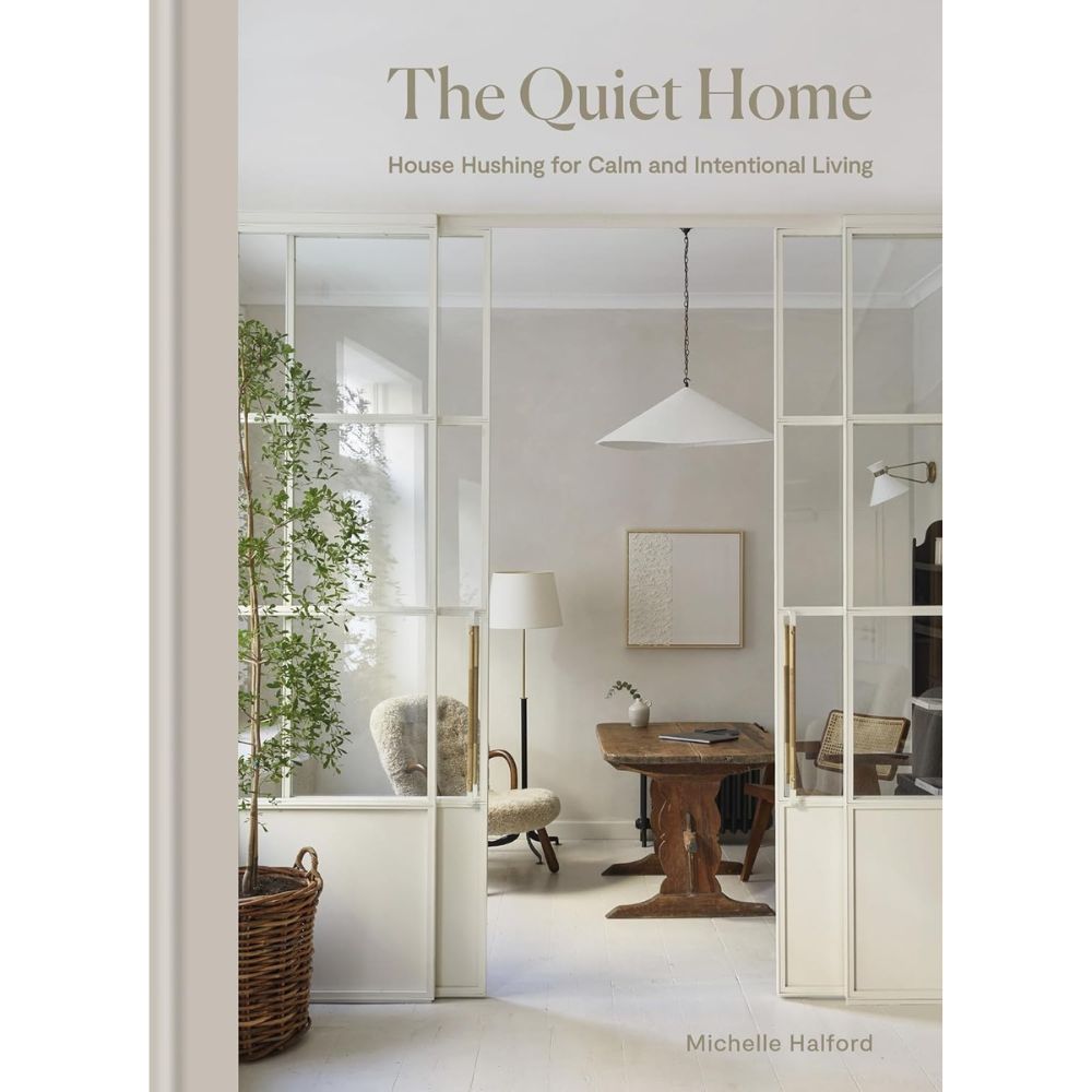עטיפת הספר "The quiet home" מאת Fine Lab Home: עיצוב הבית בסגנון מינימליזם מודע — קירות בהירים, דלתות זכוכית, שולחן עץ, כיסאות וצמח להשלמת תחושת בית רגוע.